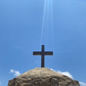 a cross sitting on top of a large rock