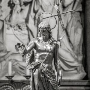 A statue of john the baptist holding a cross.